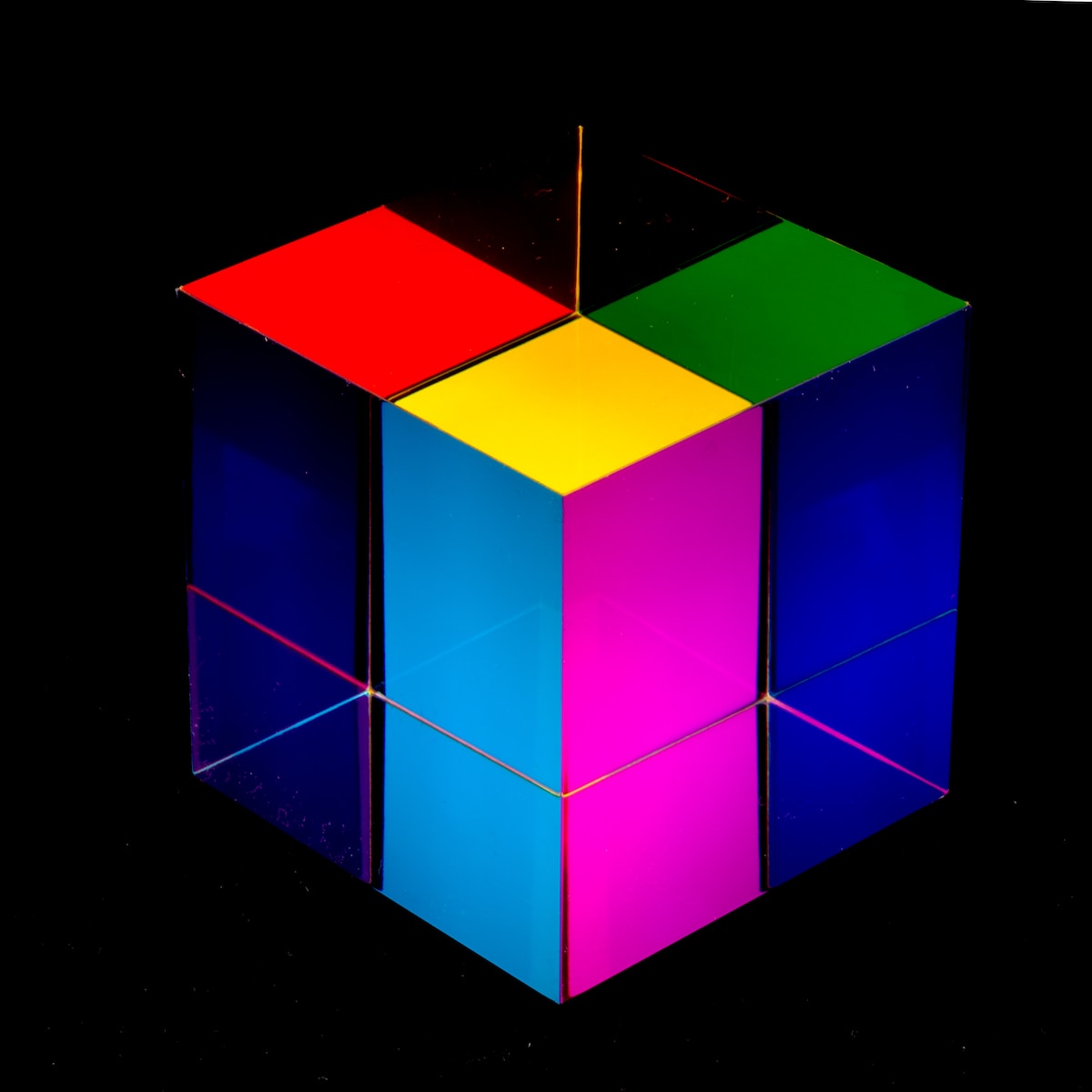 a multicolored cube sitting on top of a black surface